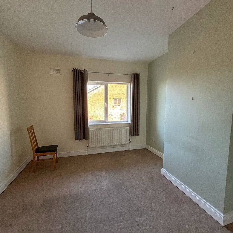 Bright bedroom in a Mullingar 3 bed property, featuring a window and neutral carpet. – Ghar.ie property listing