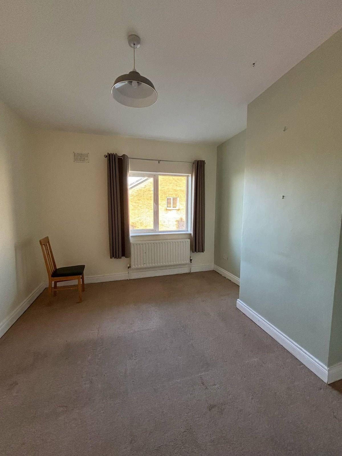 Bright bedroom in a Mullingar 3 bed property, featuring a window and neutral carpet. – Ghar.ie property listing
