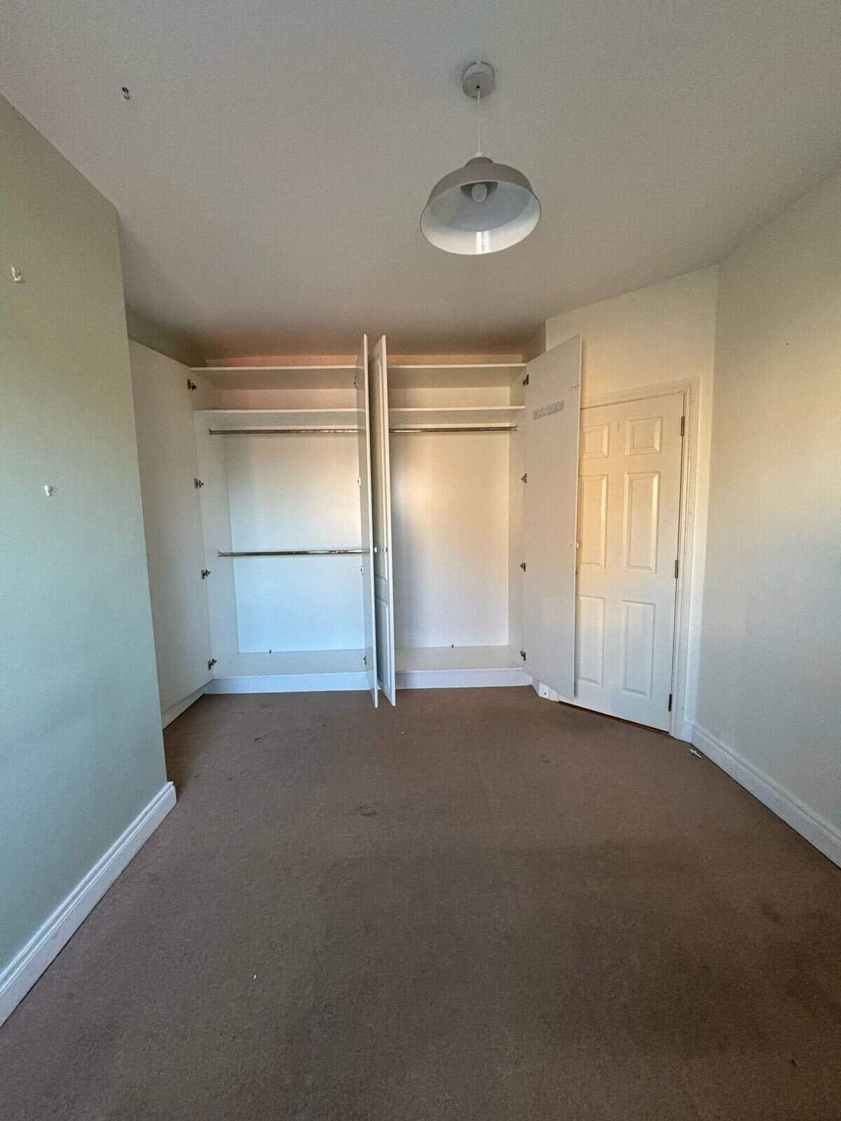 Bright Mullingar bedroom with built-in wardrobes and neutral carpet, showcasing a room in this 3 bed property. – Ghar.ie property listing