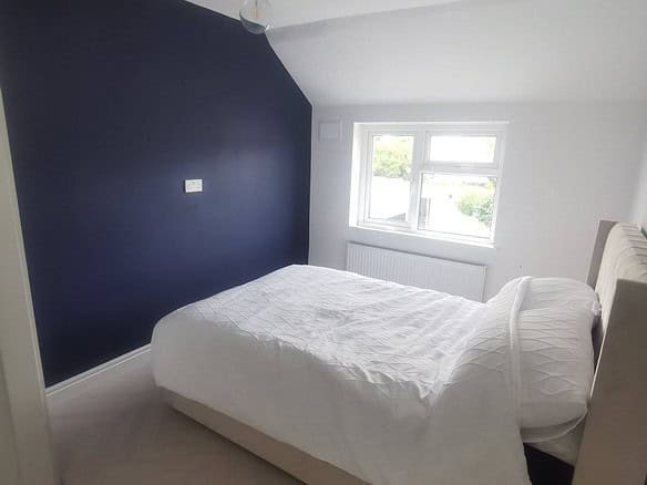 Bedroom in Raheny with a double bed, dark blue accent wall, and natural light. – Ghar.ie property listing