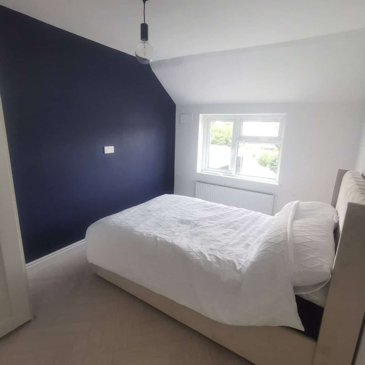 Bedroom in Raheny with a double bed, dark blue accent wall, and natural light. – Ghar.ie property listing