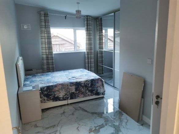 King size bed in a one bedroom apartment, featuring marble floors and neutral decor. – Ghar.ie property listing