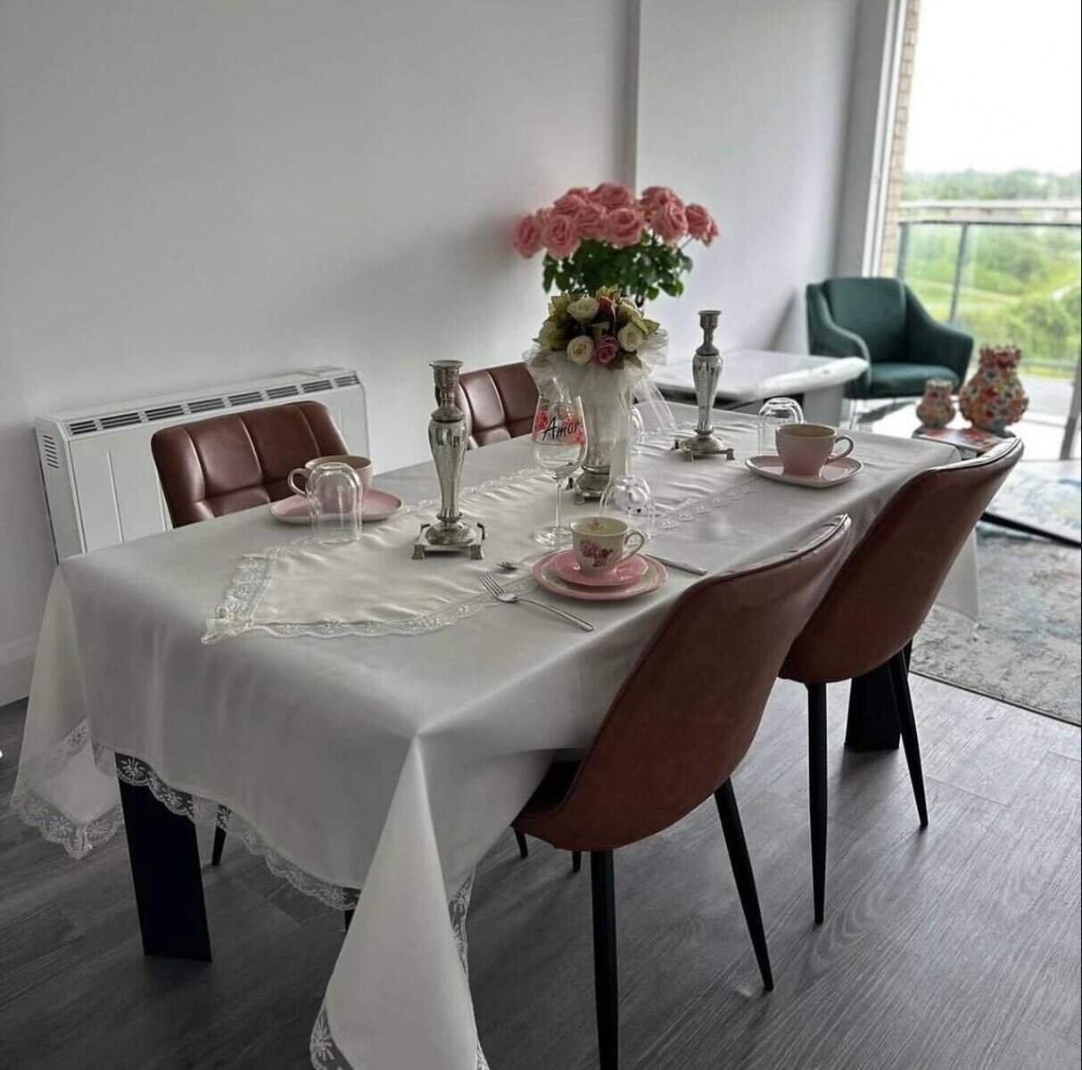 Dining room with table set for tea, featuring pink roses and brown chairs. – Ghar.ie property listing