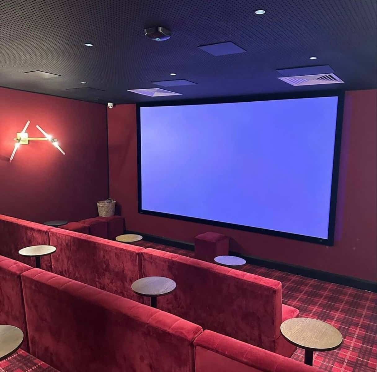 Home cinema room with red velvet seating and a large screen, perfect for movie nights. – Ghar.ie property listing