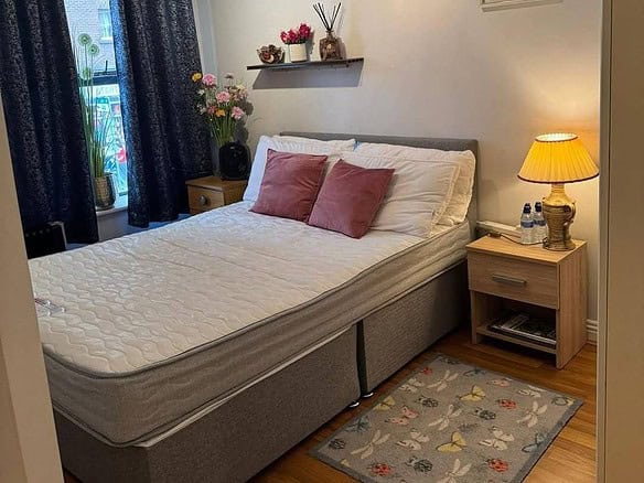 Bedroom of a fully furnished apartment for rent in Dublin 1, featuring a double bed and bedside table. – Ghar.ie property listing