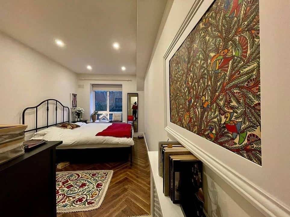 Ringsend, Dublin 4 apartment bedroom with black metal bed frame, herringbone floor, and colorful wall art. – Ghar.ie property listing