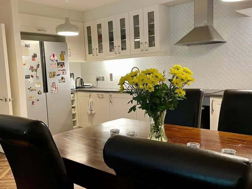 Kitchen dining area with table, chairs, and flowers in this Ringsend, Dublin 4 apartment. – Ghar.ie property listing