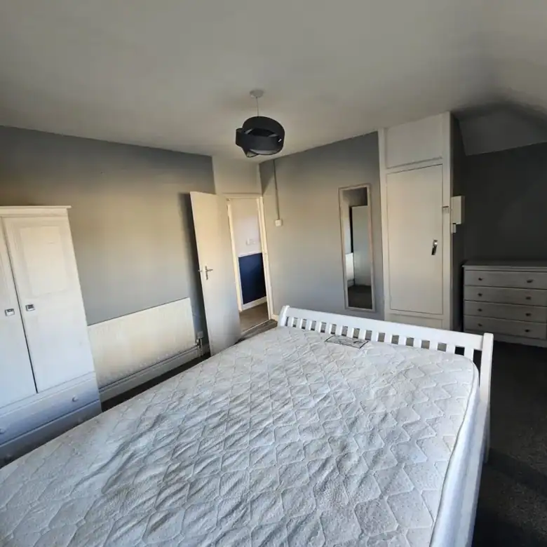 Bedroom in a 2-bedroom apartment for rent in Drimnagh, Dublin 12, featuring a bed and wardrobe. – Ghar.ie property listing