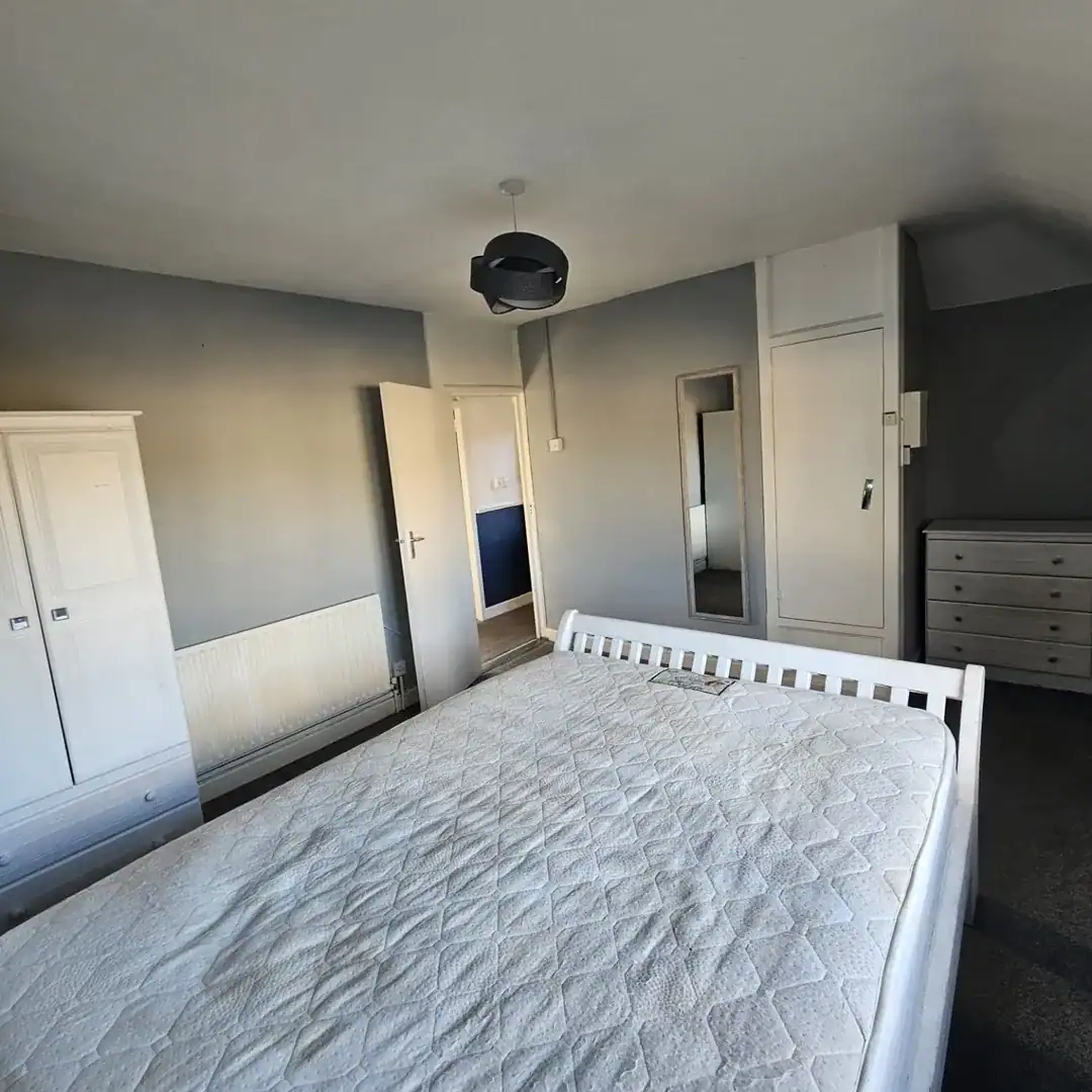 Bedroom in a 2-bedroom apartment for rent in Drimnagh, Dublin 12, featuring a bed and wardrobe. – Ghar.ie property listing