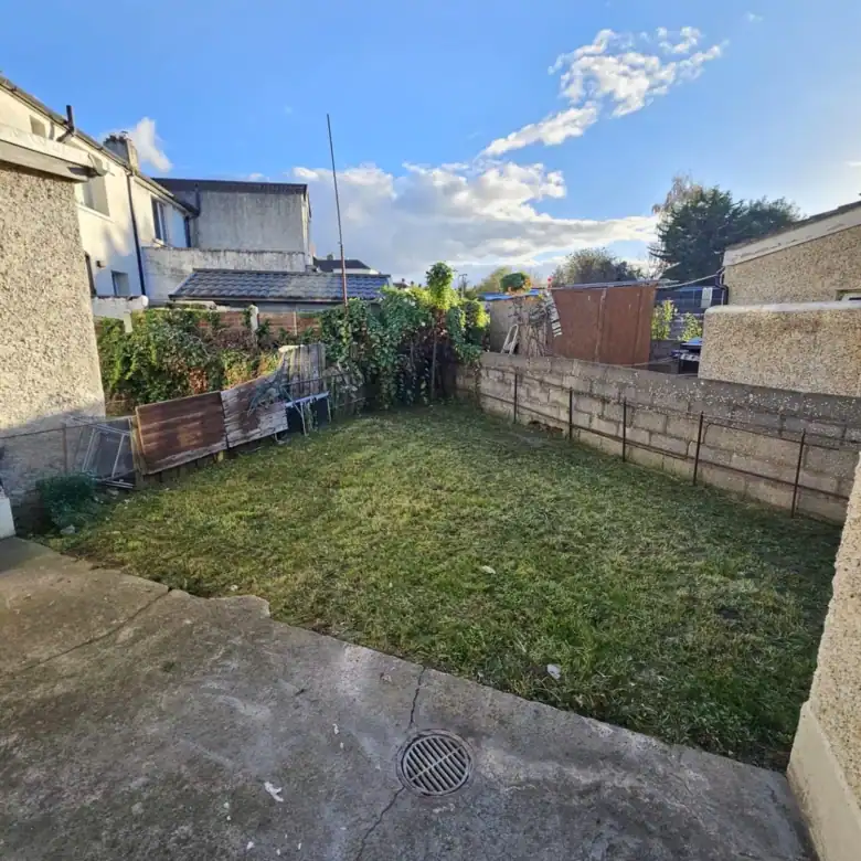 Back garden with grass, concrete walls, and shed, for this Drimnagh, Dublin 12 apartment. – Ghar.ie property listing