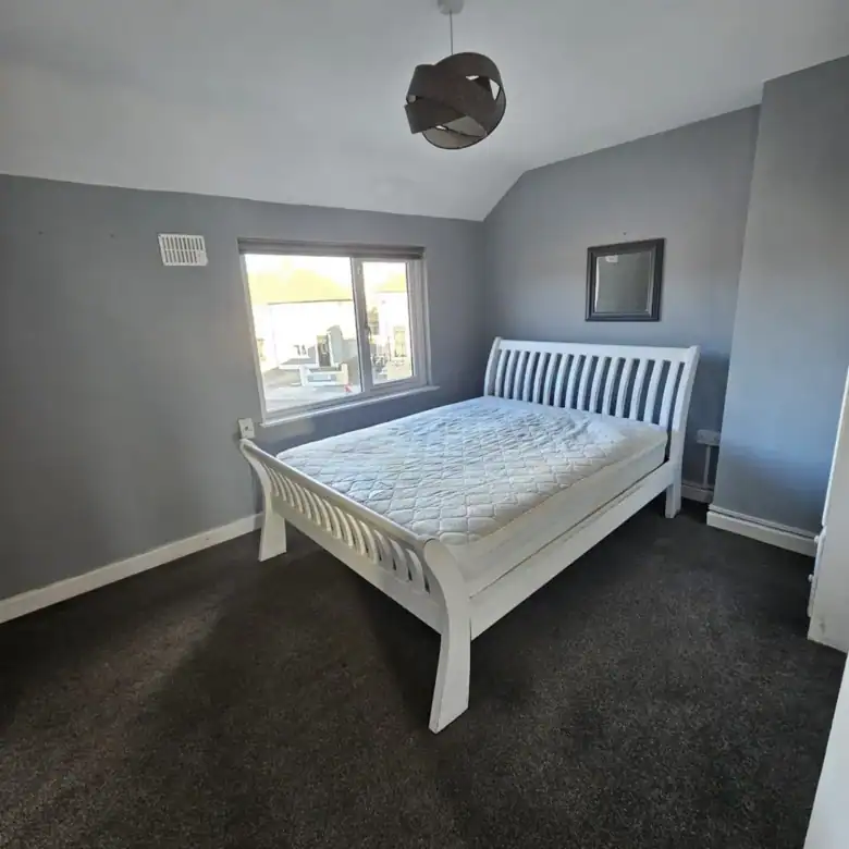 Bedroom with a white bed frame in a 2-bedroom apartment for rent in Drimnagh. – Ghar.ie property listing