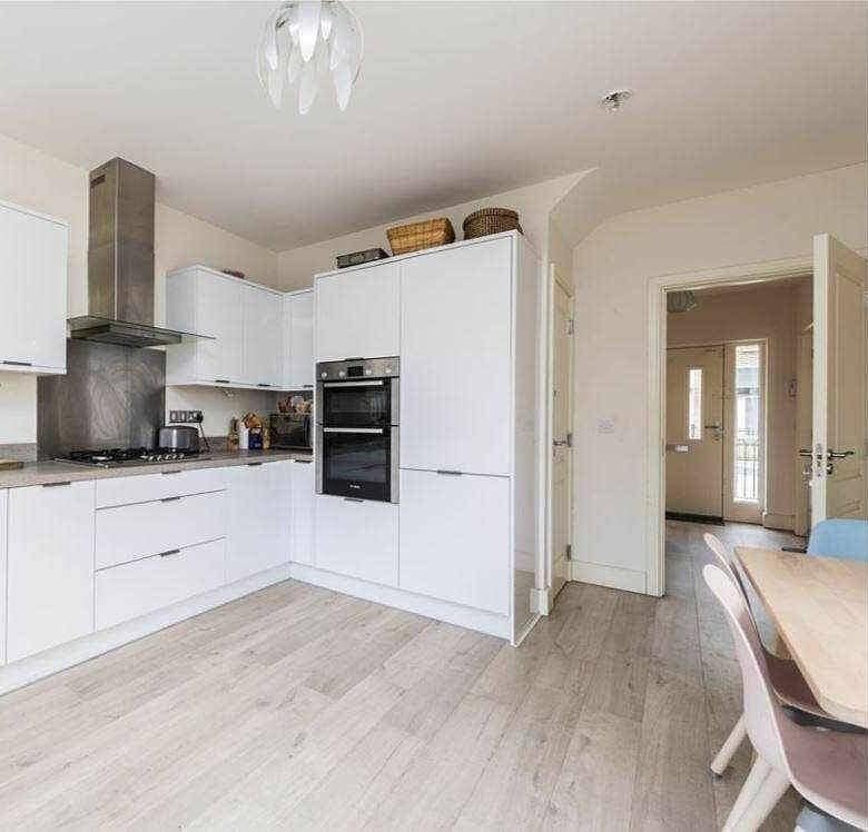 Bright modern kitchen with white cabinets and wood-look flooring, suitable for private single occupancy. – Ghar.ie property listing
