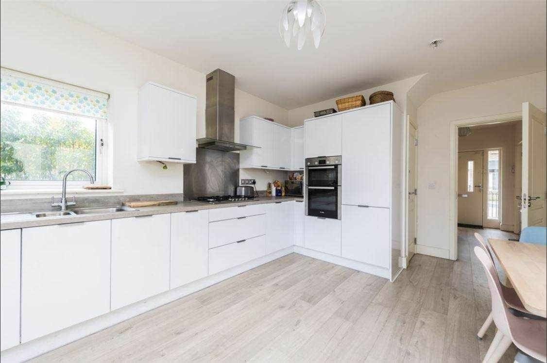 Bright modern kitchen with white cabinets and wood-look flooring, suitable for private single occupancy. – Ghar.ie property listing