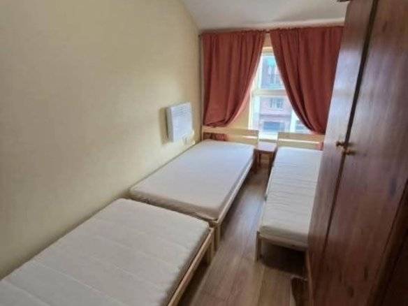 Bedroom in Dublin 1 rental featuring three single beds, wooden floors, and a wardrobe. – Ghar.ie property listing