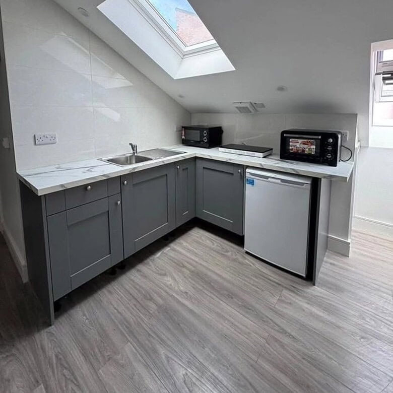 Compact studio kitchen with grey cabinets, white countertops, and a skylight in Dublin 7. – Ghar.ie property listing