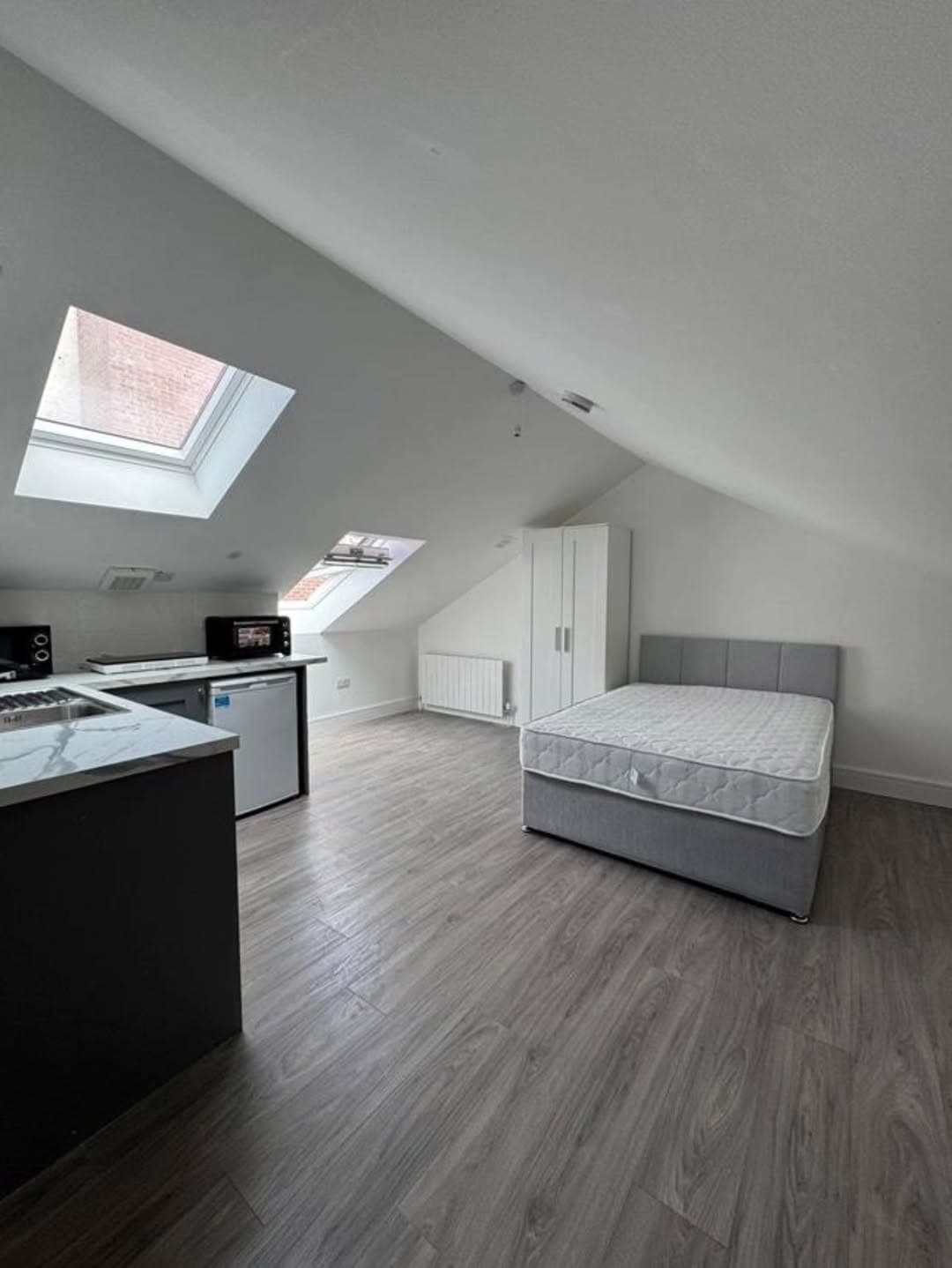 Studio apartment in Cabra West, Dublin 7, featuring a bed, kitchenette, and skylights. – Ghar.ie property listing
