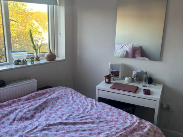 Bedroom in Blanchardstown, D15, featuring a bed, desk, mirror, and window with natural light. – Ghar.ie property listing