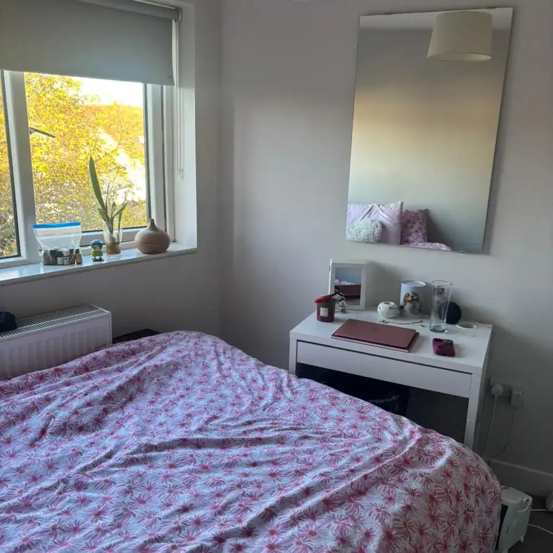 Bedroom in Blanchardstown, D15, featuring a bed, desk, mirror, and window with natural light. – Ghar.ie property listing