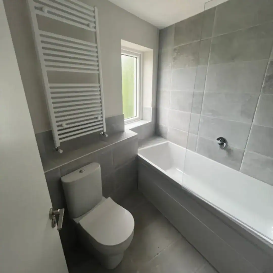 Modern bathroom with toilet, bathtub, and heated towel rack in Blanchardstown, D15 apartment. – Ghar.ie property listing