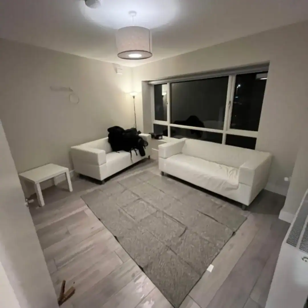 Living room in Blanchardstown with two white couches, gray rug, and a large window. – Ghar.ie property listing