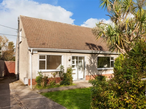 Charming single-story house with brown roof, small lawn, and palm tree in the front yard.