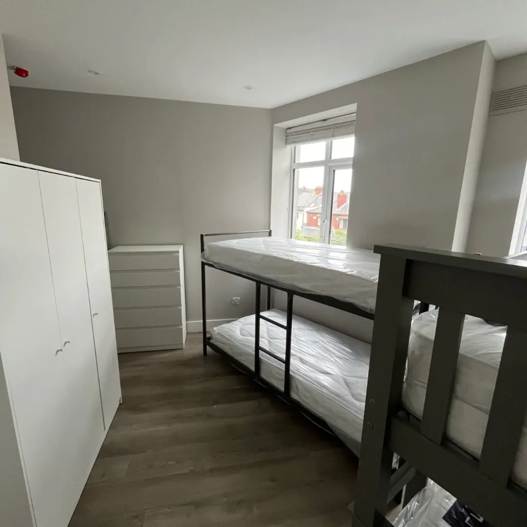 Bedroom with bunk beds, wardrobe, and chest of drawers.