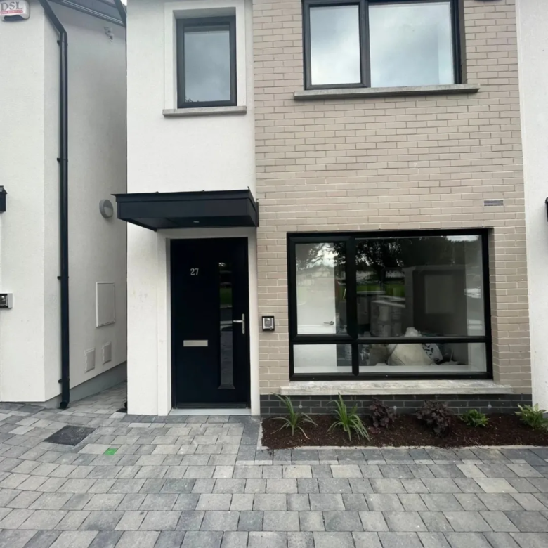 Modern home exterior with black door and window frames, number 27 visible.
