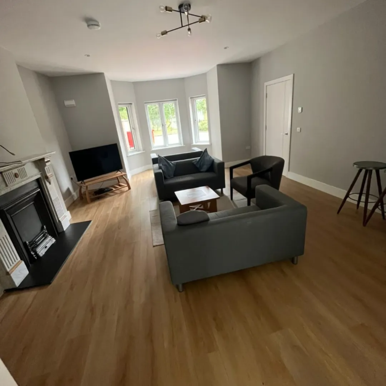 Living room with gray sofas, fireplace, and wood floors. Modern interior design.