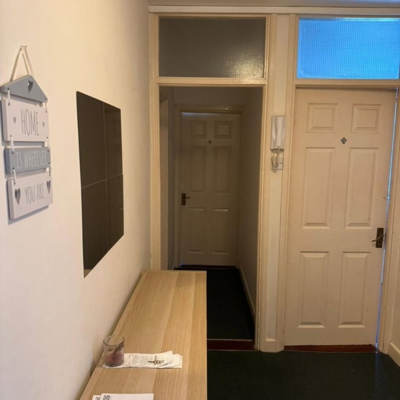 Apartment entryway with console table, decor, and interior doors.