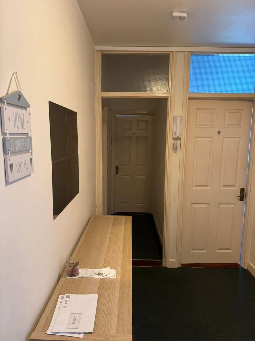 Apartment entryway with console table, decor, and interior doors.
