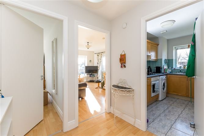 Apartment hallway with doorways to living room and kitchen.