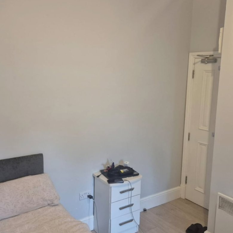 Bedroom interior with bed, nightstand, and closed door.