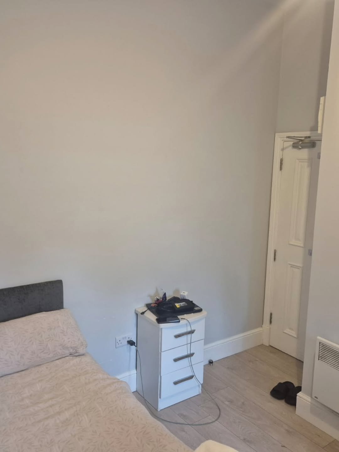 Bedroom interior with bed, nightstand, and closed door.