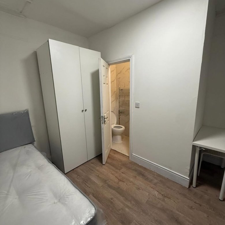 Bedroom with bed, wardrobe, desk, and ensuite bathroom.