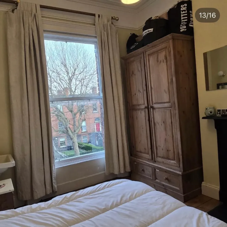Bedroom interior with bed, wardrobe, and window view of Dublin street.