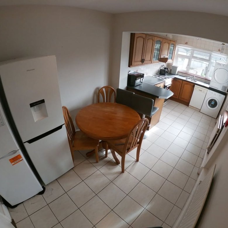 Bright kitchen with dining area, refrigerator, and washer/dryer.