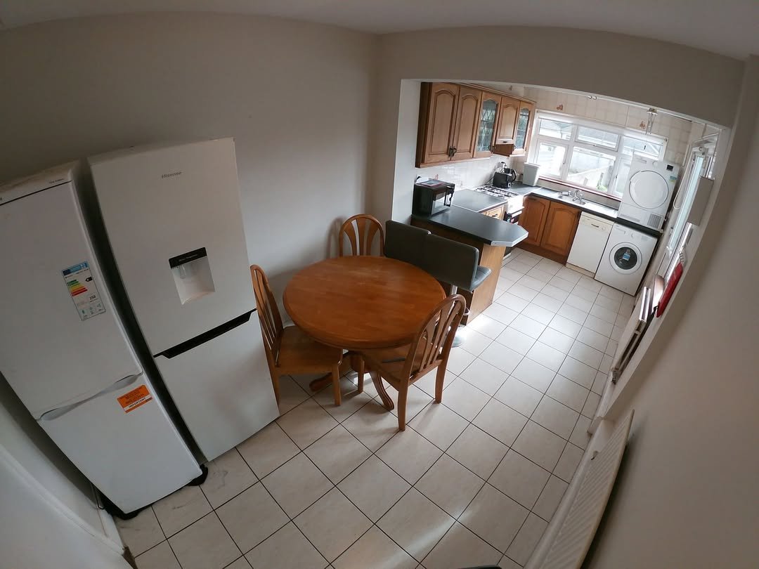Bright kitchen with dining area, refrigerator, and washer/dryer.