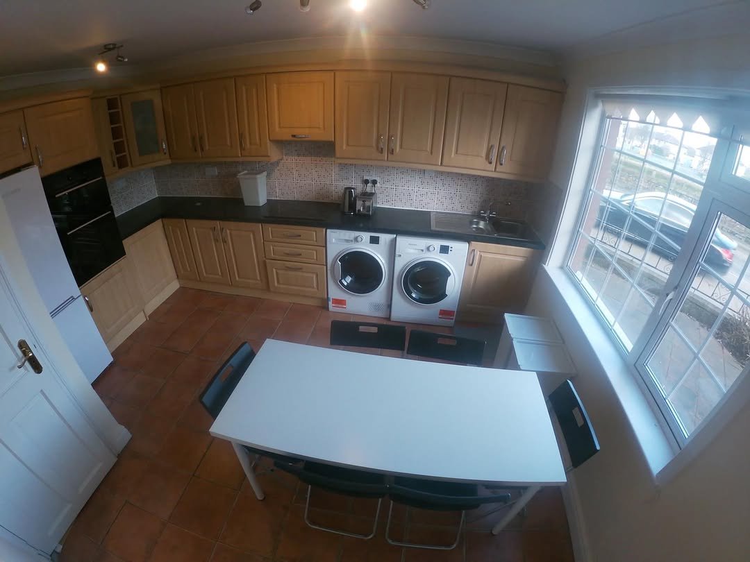 Bright kitchen with dining table, washer/dryer, and large window.