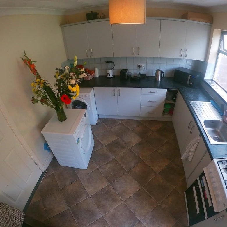 Bright kitchen with white cabinets, appliances, and a bouquet of flowers.
