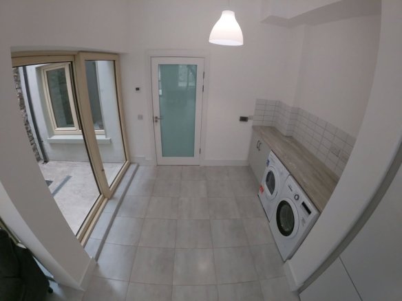 Bright laundry room with washer, dryer, and garden access.