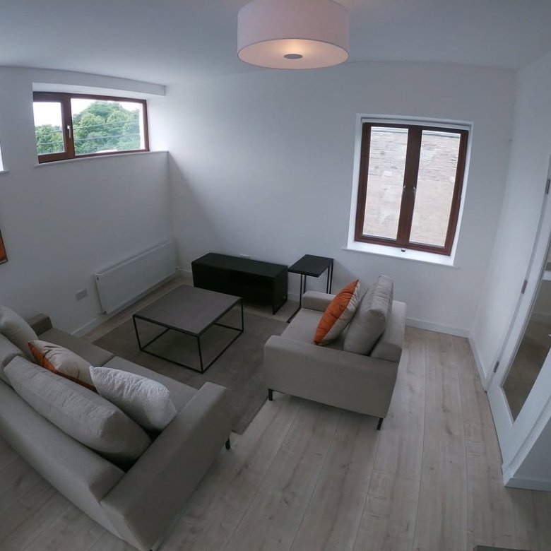 Bright living room with beige sofa, gray coffee table, and natural light.