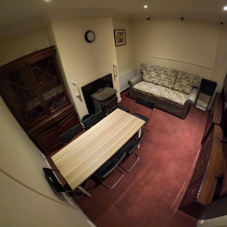 Cozy living room with dining table, sofa, and dark wood furniture.