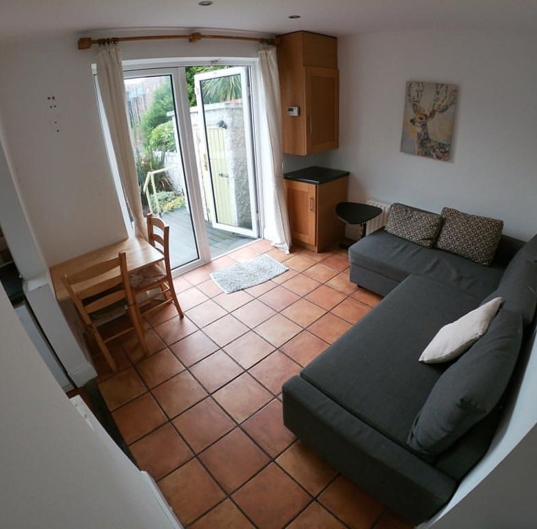 Cozy living room with gray sofa, dining table, and patio access.