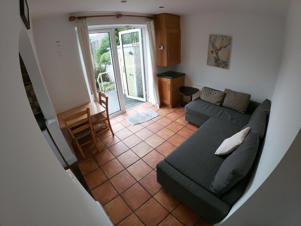 Cozy living room with gray sofa, dining table, and patio access.
