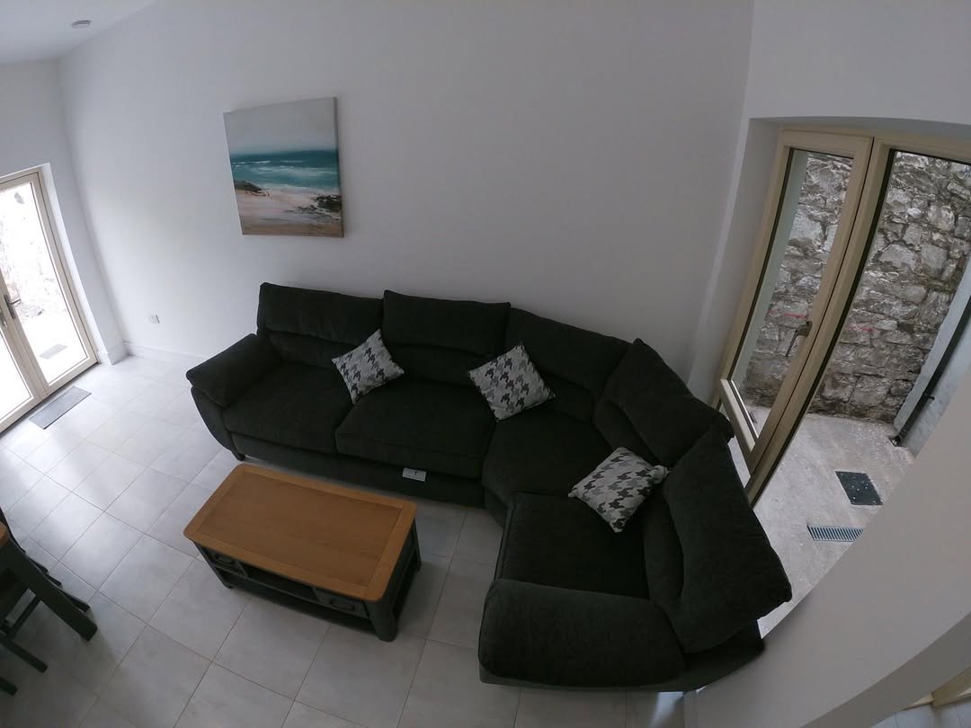 Living room with dark gray sectional sofa, coffee table, and coastal art.