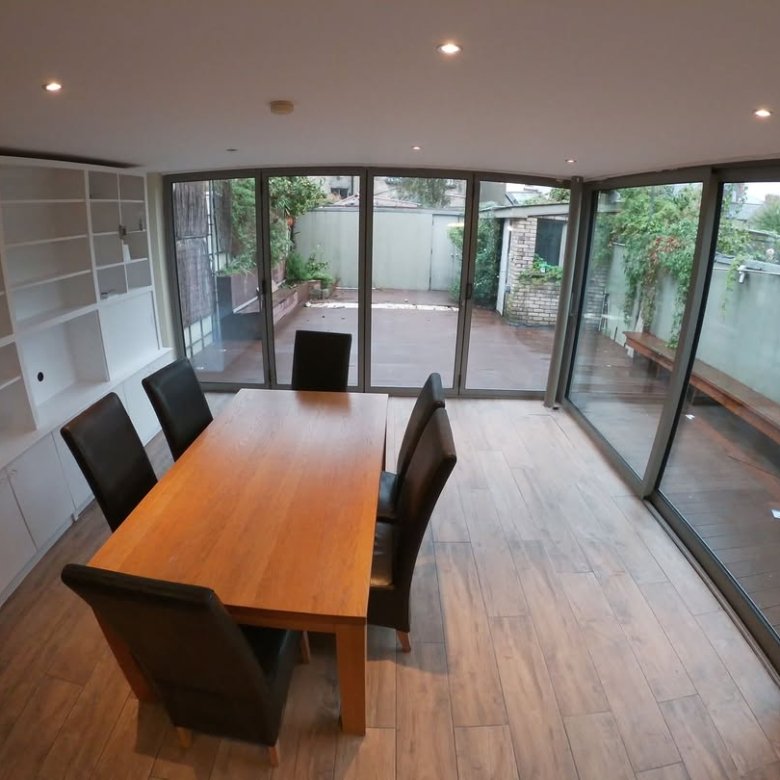 Dining room with wood table, chairs, and sliding glass doors to a patio.
