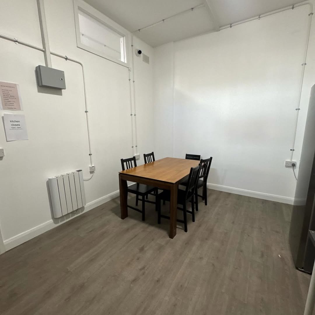 Dining area with wooden table and black chairs in a bright room.