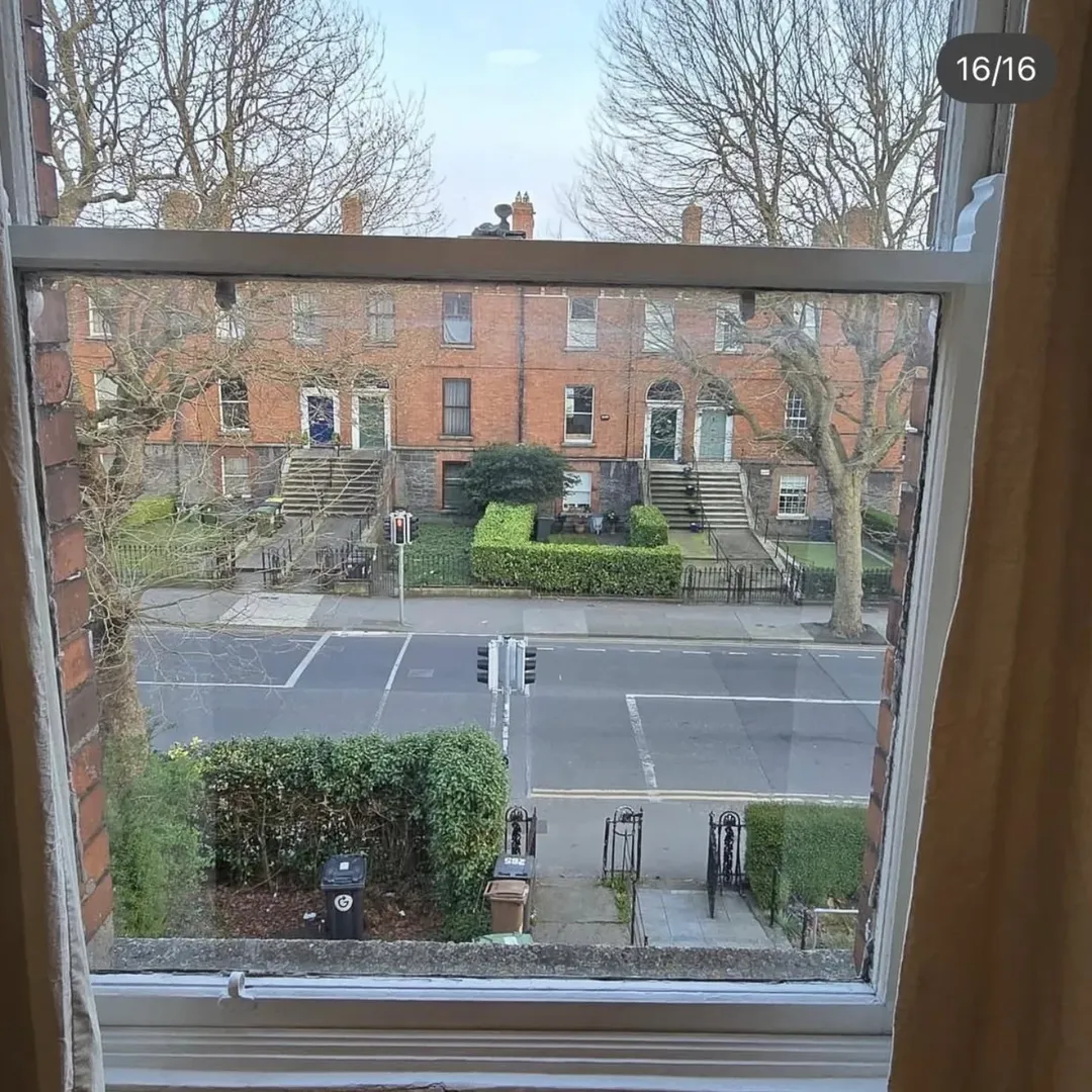 View from window of Dublin street with Georgian buildings and crosswalk.