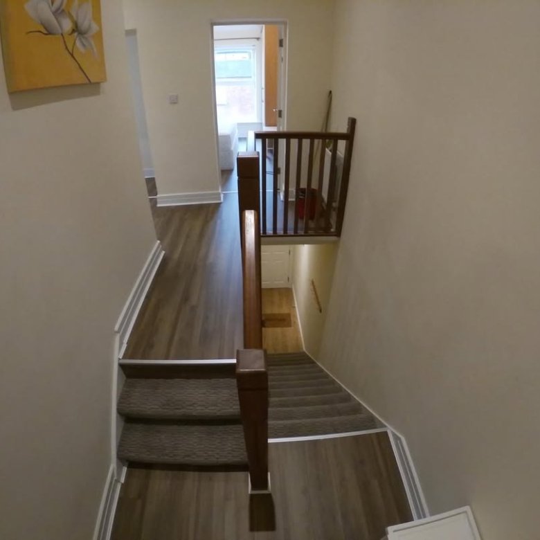 Interior view of a home's stairway with wood and carpet steps.