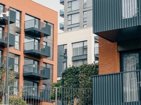 Modern apartment buildings with balconies and brick facade in an urban setting.